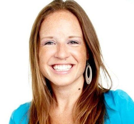 A woman with long hair and big smile.