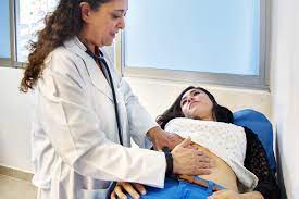 A doctor is examining the stomach of a patient.