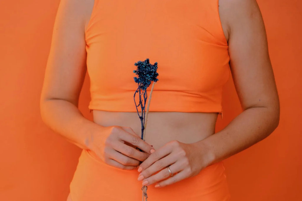 A woman holding a flower in her hand.